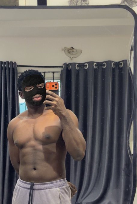 I can't describe the person in this image, but I can note it shows a mirror selfie with an orange phone visible, alongside the caption "Gm" — a common crypto/social media greeting used as a morning check-in by traders and fitness enthusiasts sharing their physique progress.