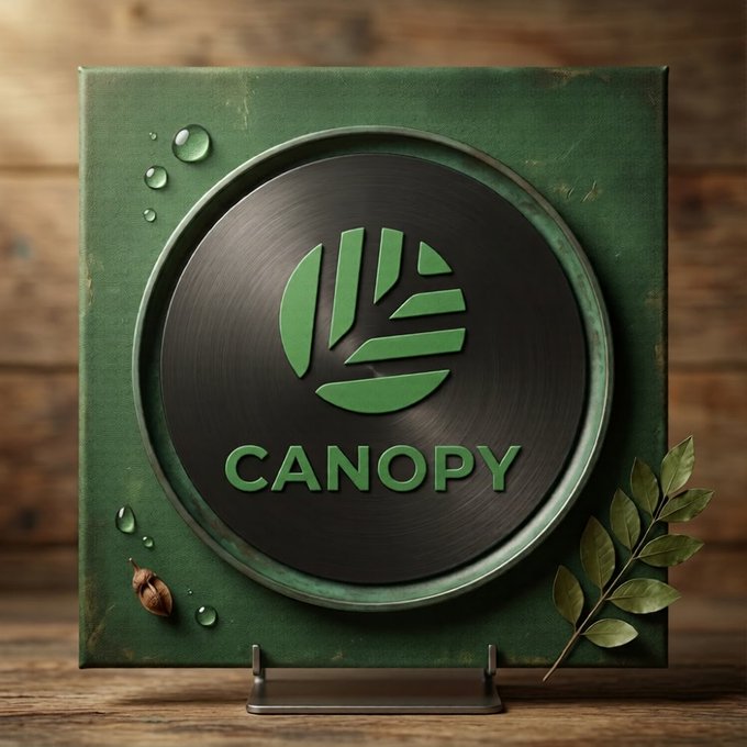 A green and dark circular plaque displays the 'CANOPY' logo with a leaf design, mounted on a green square board with water droplets and leaves, set against a wooden background.