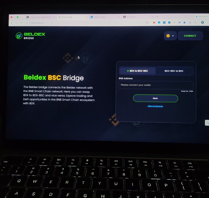 A laptop displaying the Beldex BSC Bridge website, with the Beldex logo, bridge interface, and options for 'BDX to BDX-BSC' and 'BDX-BSC to BDX' conversions.