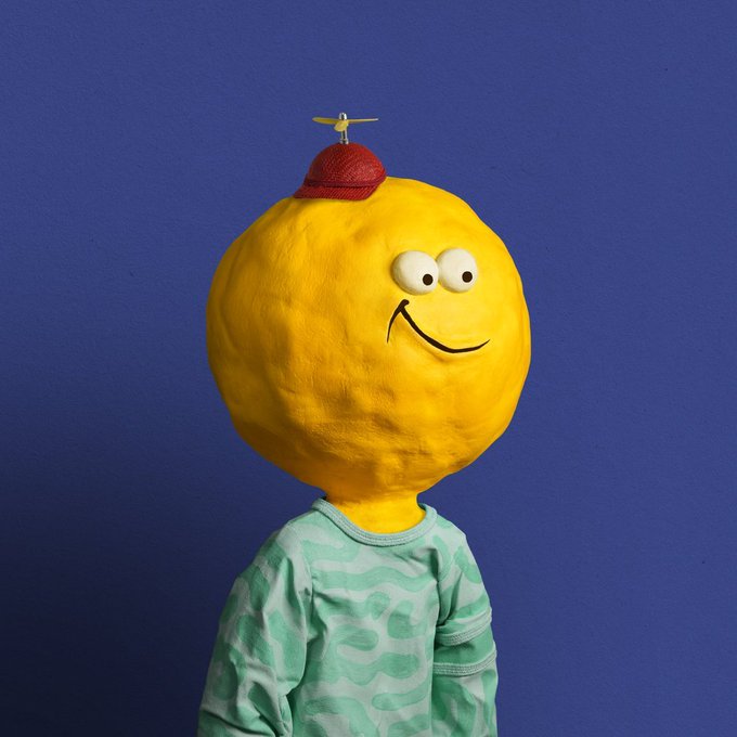 The focus of the image revolves around a creative costume or doll that resembles an onion head along with a toy plane perched atop its head. It's important to understand how this unique creation is tied to the Appreciators' IO campaign, which has been described as "the dumbest part about @Appreciators_IO’s BE ORIGINAL campaign isn't just the $10,000 APE reward pool". The costume stands out due to its originality and imaginative design.