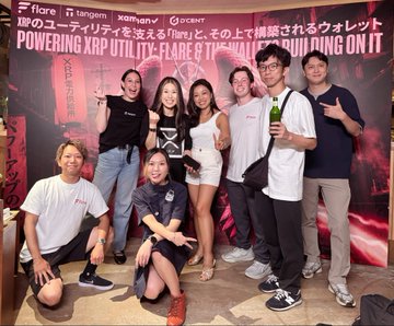 A group of eight people pose together at a Flare Networks (XRP) event in Tokyo, holding a branded box in front of a backdrop that reads "Flare × XRPLユーティリティ・フレア & XRPがテーマで開催されるウォレット POWERING XRP UTILITY." The image captures the celebratory atmosphere of the successful Flare Japan event highlighted in the post.