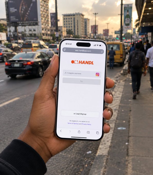 A hand holding a smartphone displaying the app.handi4pay.com login screen with the HANDL logo and an Instagram username field, set against a busy city street.
