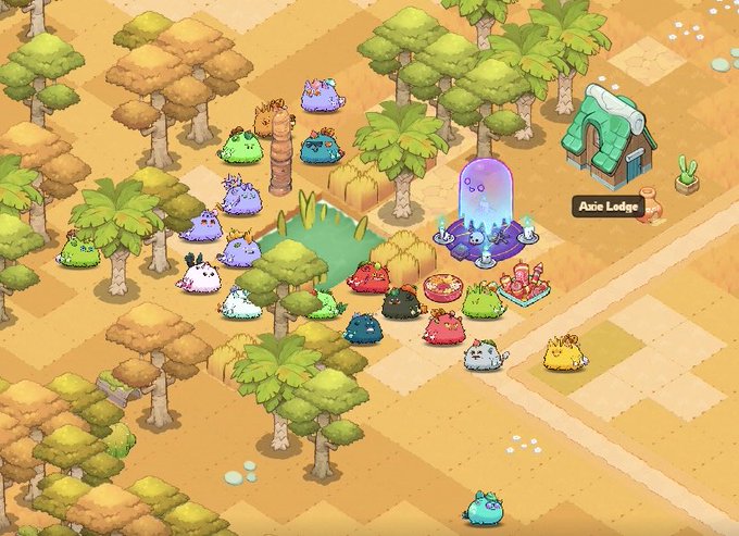 A screenshot from the mobile game Axie Infinity showing a colorful village scene with various axie creatures gathered around an 'Azie Lodge.'