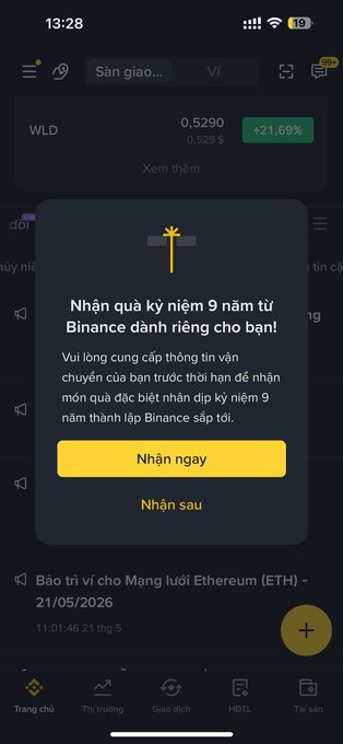 The image shows a phone screen with a message displayed that says "Ở Binance nhận quà ngán luôn là có thật anh em ạ, Swag 9 năm kỷ niệm sinh nhật của Binance, anh em nào bộ swag có mấy anh em bán vài trăm đô". The phone screen is located in the upper right corner of the image.

The post appears to be a message from someone named "Binhân" who has sent the message to another person, possibly a friend or family member. The message includes an attachment with a photo and some text.