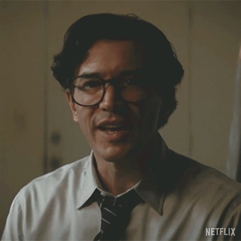 The image shows a man wearing glasses, a white shirt, and a tie with a Netflix logo at the bottom right corner of the frame. There are no other objects or text visible in the image. The caption provided seems to be unrelated to the main subject matter of the photo.