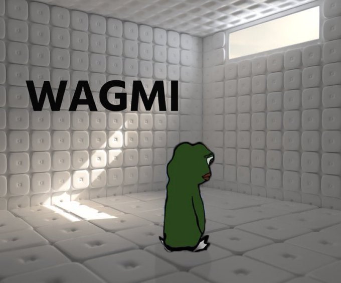 An illustration of the "WAGMI" meme, featuring a sad green frog sitting in a corner on a padded white floor with the word "WAGMI" written on the wall.