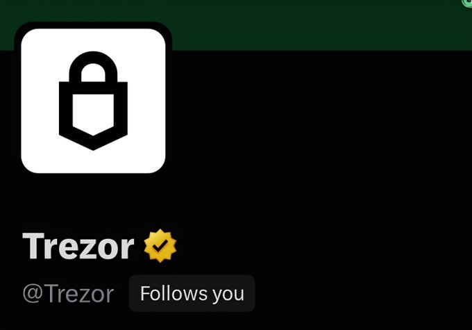 A Twitter/X profile for 'Trezor' (@Trezor) showing their padlock logo and a 'Follows you' badge.