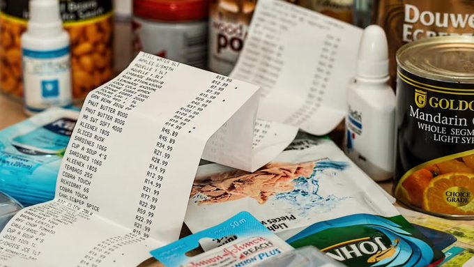 Grocery items including a receipt, canned goods like Golden Mandarin, and other packaged products scattered on a surface.