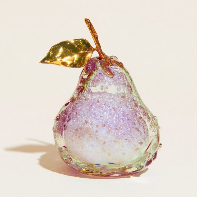 A decorative art glass pear sculpture featuring a pearlescent purple/lavender body with bubble textures, accented with a golden leaf and stem on top.