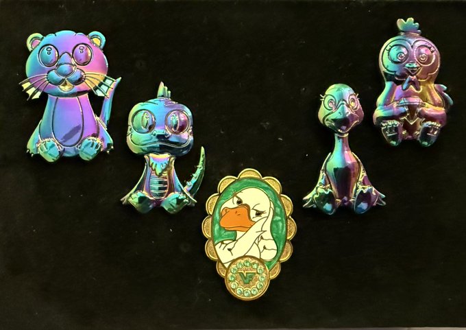 urn of gold and blue, silver dragon, green bird with a flower, purple cat, and four animal figurines arranged on a black background.