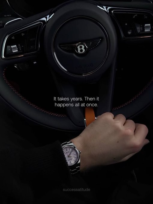 llor logo on a black steering wheel, with the driver's hand holding the gear shift and a quote above it.
