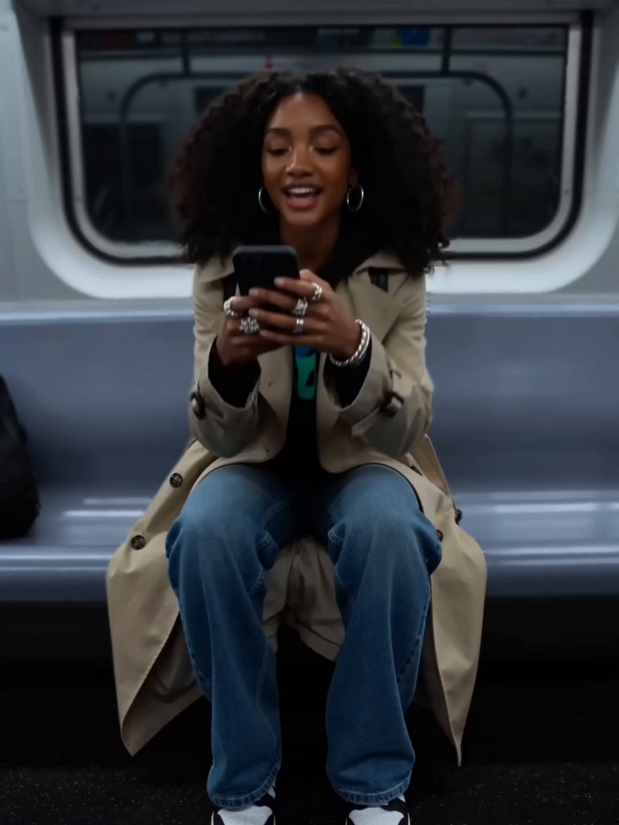 The image shows a woman sitting on a bench, looking at her cell phone with a smile on her face. She appears to be enjoying herself as she checks her phone. The photo has been captioned "Just use Jupiter" which suggests that the woman is using an app or service from Jupiter.