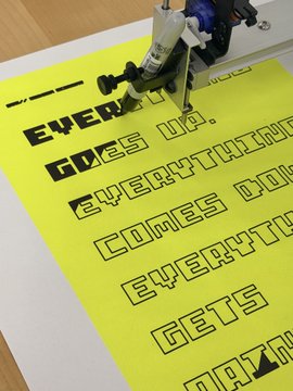 Yellow poster being printed by a machine with the text '...EVER... GOES UP... EVERYTHI... COMES DO... EVERYTH... GETS R...' visible in bold stencil-style lettering.
