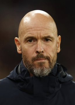 A close-up portrait of a bald, bearded man in a black jacket looks directly at the camera. The accompanying post quotes Ten Hag criticizing Cristiano Ronaldo’s focus on brand and profit, though no readable text or names appear in the image itself.
