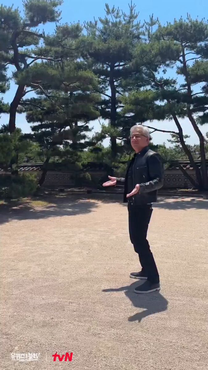 The image features a man standing in front of trees, wearing a black jacket and jeans while holding his arms outstretched. The surrounding area appears to be a dirt field with some grass visible. There are also two other people present in the scene, one located near the center-left side of the image and another person closer to the right edge of the frame.

The post includes an image of the man's face along with text that reads "黃仁勳不務正業跑來拍MV啊 他這個手勢是在暗示要拉盤了嗎 up up up 求求加密貨幣給我拉盤啊 @RiverdotInc #river". The man in the image is holding his arms outstretched, which adds a dynamic element to the scene.