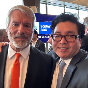 Two men pose together at what appears to be a corporate event celebrating "SQUAW BOX 30 YEARS," with one wearing an orange tie and the other in a dark suit with glasses, likely taken in connection with coverage of corporate crypto treasury purchases, including Strategy's acquisition of 4,603 $BTC.