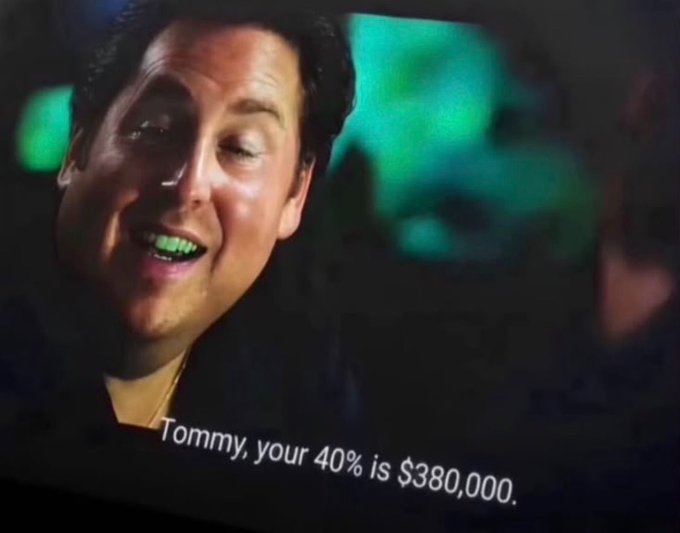 A screenshot of a man smiling in a dark setting with the subtitle text 'Tommy, your 40% is $380,000.'