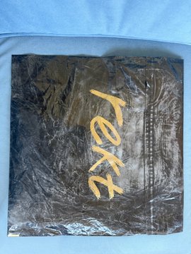 The image features a black and white photograph of a piece of paper with the word "REKT" written on it, which appears to be a part of a package or an item for sale. The background of the photo is blue, providing a contrast to the black and white elements in the foreground. The text "gM ?" suggests that there might be more information about this product or service available, but we cannot determine its relevance from the image alone.