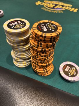 Two stacks of orange and black SHRPO (Seminole Hard Rock Poker Open) poker chips sit on a green felt table, with one stack displaying a "$500" denomination, illustrating a poker tournament session in progress.