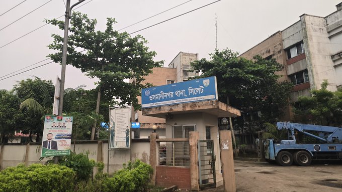 The image shows the entrance of "Islamiabad Bar, District Court," a district court building in Dhaka, Bangladesh, with a blue signboard featuring a police emblem. The mention of filing a legal case and the bar association's name suggests the poster may be considering or referencing legal action at this district court in Bangladesh.