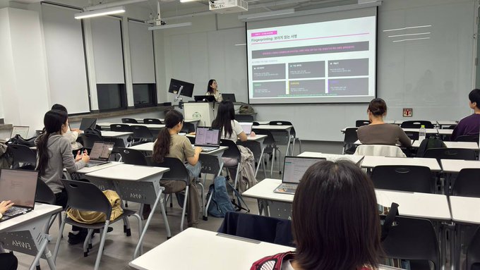 A classroom or lecture hall scene shows attendees with laptops watching a presentation slide titled 'Programmatic 구도 SEO 전략' on a projector screen.