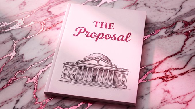 A pink book titled 'THE Proposal' featuring an illustration of a classical columned building on its cover, resting on a pink and white marble surface with rose gold veining.