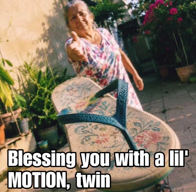 A meme image showing an older woman in a floral dress pointing forward in a courtyard, with text reading 'Blessing you with a lil' MOTION, twin'.