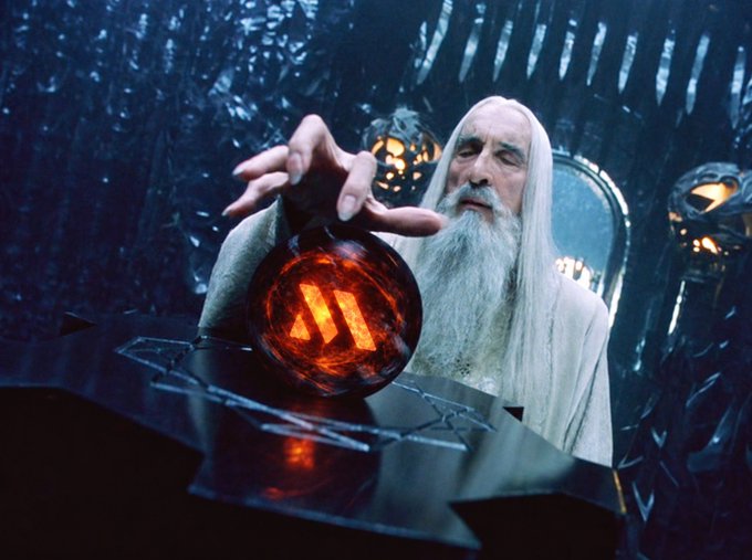 An elderly white-haired wizard in a pale robe reaches toward a glowing red orb on a table in a dark, icy chamber.