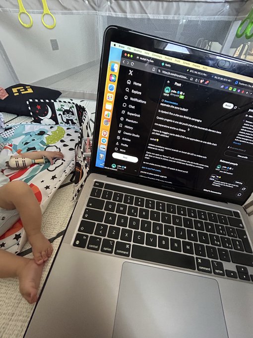 A child lies on a bed near a laptop displaying the X (formerly Twitter) social media platform interface in dark mode.