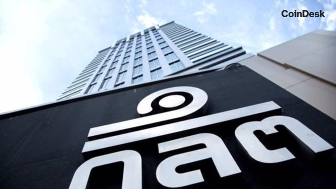 A low-angle shot captures a modern high-rise building against a blue sky, featuring a prominent white sign displaying the Thai letters "กลต" (the Thai abbreviation for the Securities and Exchange Commission) in the foreground, with the CoinDesk logo in the top right corner. The image visually represents the Thailand SEC headquarters responsible for issuing the new Travel Rule for digital assets.