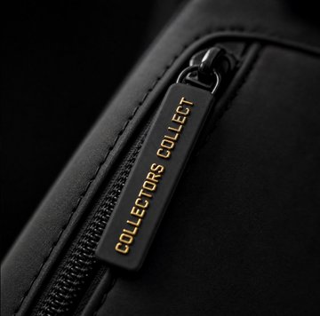 A close-up shot of a black zipper pull with the text 'COLLECTORS COLLECT' printed in gold.