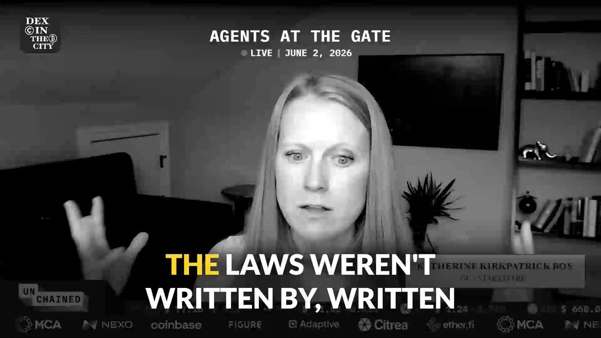 The image shows a woman sitting at a desk with her hands raised as if she's speaking or gesturing during an interview. The background of the image features a TV screen displaying text, possibly related to the content being discussed by the woman on the screen. The text includes phrases such as "The laws were written by", "The laws were written by", and "@DEXintheCityPod". Additionally, there are mentions of Bitcoin and dormant Bitcoin wallets in the context of the post.