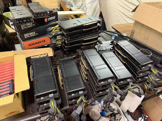 Stacks of used NVIDIA GeForce GTX 1660 Ti graphics cards from MSI and Gigabyte are piled together alongside their original boxes, with tangled power cables spilling out—visually echoing the post's "It's time" as a setup ready for a mining rig or hardware project.