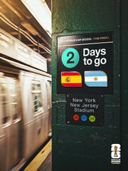 A subway platform sign displays a countdown: '2 Days to go' for a New York/New Jersey/Stadium event, with Spain and Argentina flags shown, as a blurred train passes by.