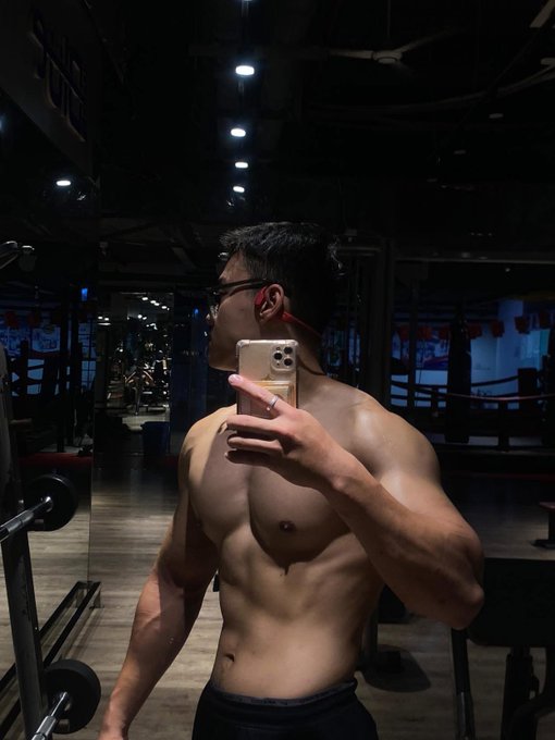 A man takes a mirror selfie at a gym, showcasing his physique. The post reflects on a previous peak physical condition, with the caption "Ăn mày quá khứ 1 tý, bao giờ mới về lại được như thế này đây @quipnetwork @CNPYNetwork" expressing a desire to return to that level of fitness.