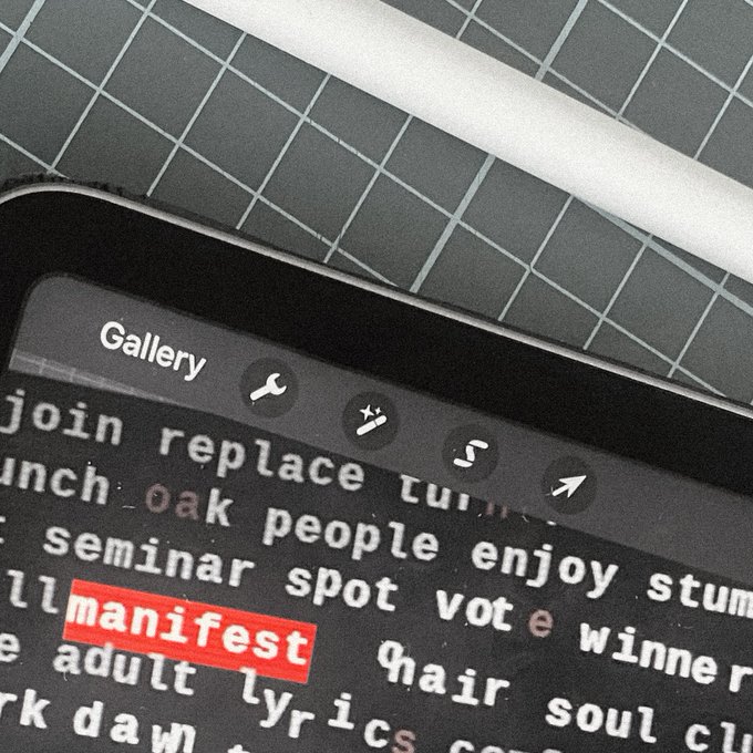 A close-up photograph of a smartphone screen displaying a word list in a 'Gallery' menu, with the word 'manifest' highlighted in red among other terms like 'oak', 'people', and 'soul'.