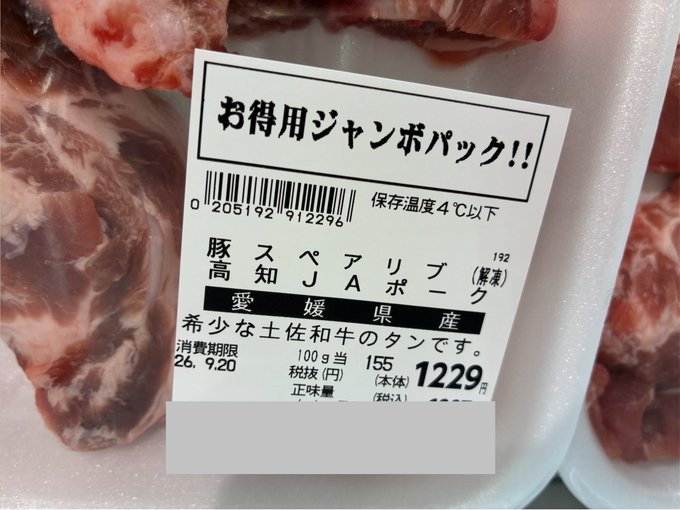 A Japanese meat label priced at 1229円 sits on raw pork, noting it as a 'rare find' (稀少) 100g serving of thickly sliced tongue from Tosa beef raised in Ehime Prefecture.