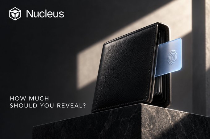 An advertisement for "Nucleus" showing a black leather wallet on a pedestal with a translucent card displaying a fingerprint icon, alongside the text "HOW MUCH SHOULD YOU REVEAL?"