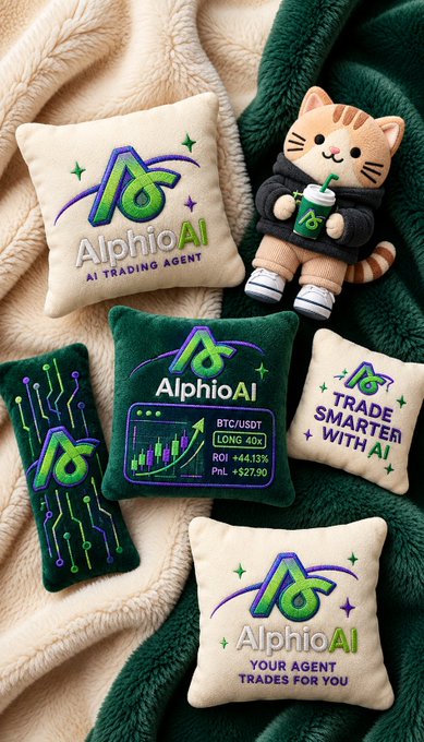 A promotional image featuring AlphioAI merchandise including embroidered pillows and a plush cat mascot, displaying branding for an AI Trading Agent with text like 'AlphioAI', 'AI TRADING AGENT', 'BTC/USDT LONG 40x', 'TRADE SMARTER WITH AI', and 'YOUR AGENT TRADES FOR YOU'.