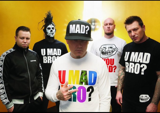 A promotional photo of the band Limp Bizkit featuring five members wearing shirts and hats with the phrase 'U MAD BRO?' against a yellow background.