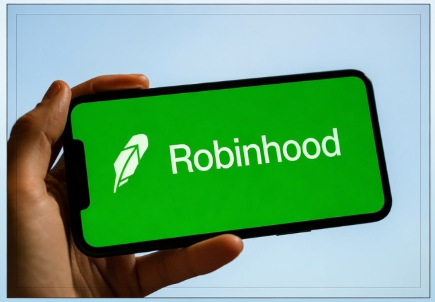 A close-up of a hand holding a smartphone displaying the green logo and text for 'Robinhood', a financial services company.
