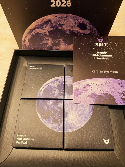 Photo of an XBIT 'Happy Mid-Autumn Festival' promotional gift box featuring a purple moon design, four smaller 'To The Moon' boxes inside, and a card dated 2026.