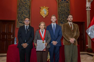 Four individuals pose in a formal room with wood paneling and a Peruvian flag, holding a framed certificate or award, with one woman wearing a medal around her neck. The image appears to document the launch of the "Alliance for the Technological Sovereignty of the Peruvian State," an initiative between Clarity DAO (ClearContracts), UNMSM (San Marcos University), and Peruvian authorities, leveraging Cardano and Midnight Network blockchain infrastructure.