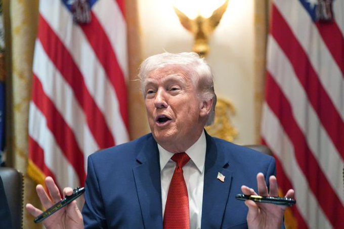 Donald Trump, seen here with the American flag behind him, is reportedly linked to $635 million in royalties from his meme coin.