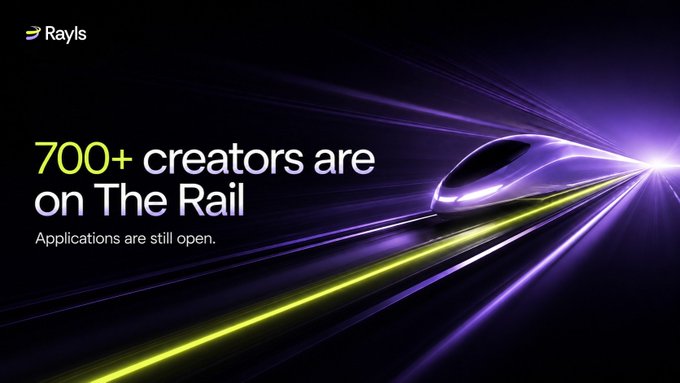 A sleek futuristic train speeds along glowing purple and yellow light trails, accompanied by the Rayls logo and the message "700+ creators are on The Rail. Applications are still open." — visually reinforcing the momentum and growing community of creators joining The Rail.