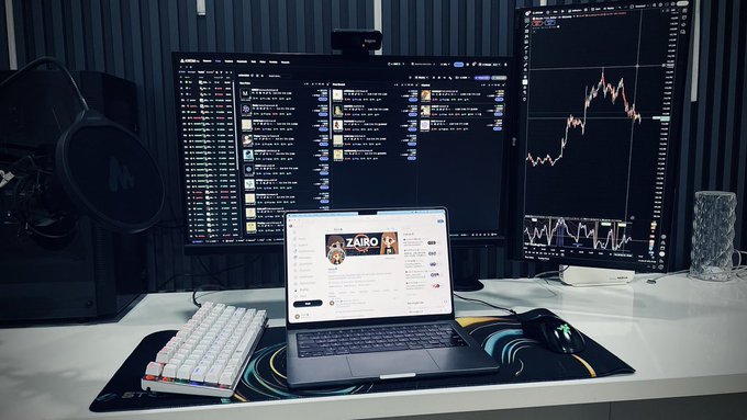 A dual-monitor trading setup displays a crypto price chart on the right and a Twitter feed in the center, with a laptop in front showing a tweet from "ZAIRO" announcing a "$10 Giveaway" that requires followers to RT, Like, and drop a SOL address for a chance to win within 24 hours.