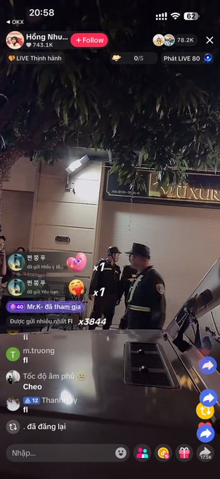 A TikTok livestream from user "Hồng Nhu" showing two security guards walking past a storefront at night, with viewers commenting and sending gifts like "Mr.K đã thăm gia" and "Dược gửi nhiều nhất Fl" in the chat, aligning with the post's caption suggesting the subjects are leaving.