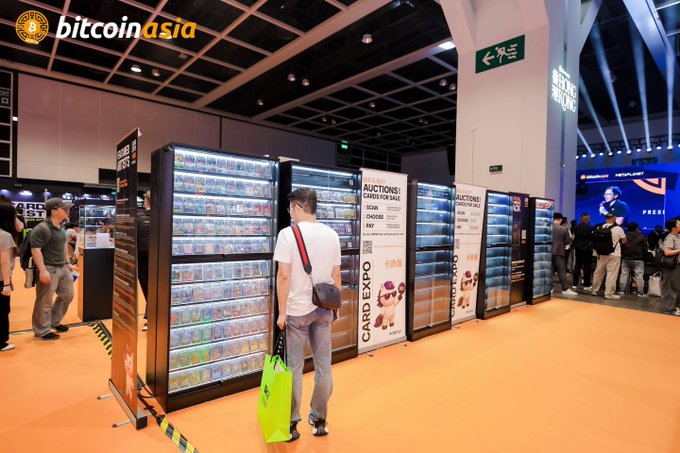 A convention hall scene from a Bitcoin Asia event showing a 'CARD EXPO' vending area with multiple card display cases and attendees browsing.