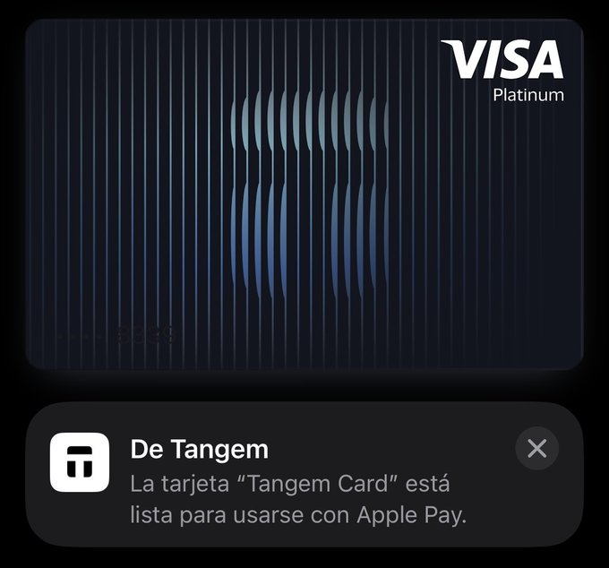 The image shows a credit card application screen with a Visa Platinum card displayed, along with a message in Spanish that reads "De tangém la tarjeta 'TANGEM CAR' está lista para usarse con Apple Pay". The focus of this image is on the credit card application process and how it can be used to make purchases using the app.