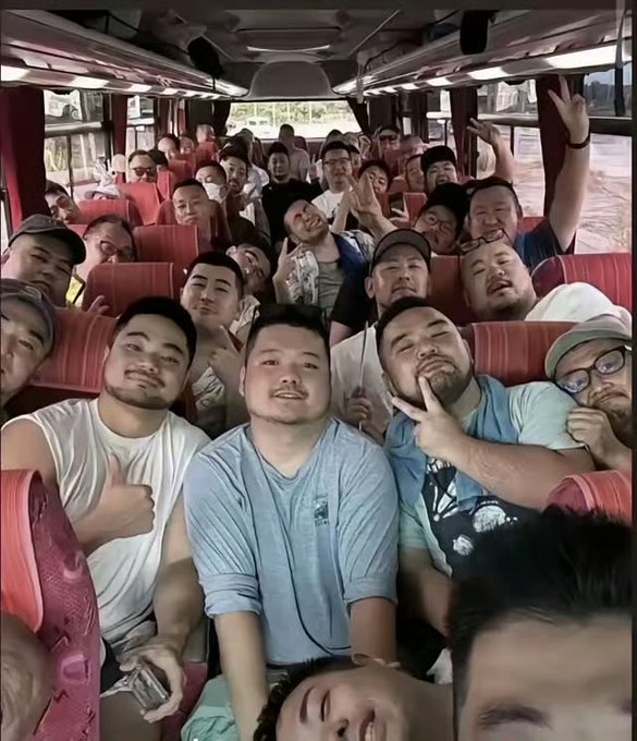 A group selfie of fans smiling and posing inside a tour bus, likely traveling to the concert venue.